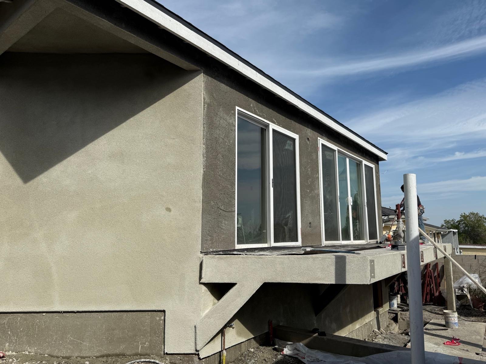 Hillside room addition with cantilevered window wall